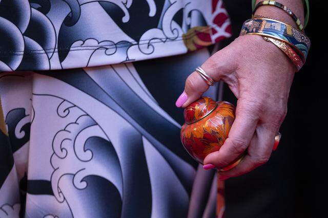 John L. Burton’s daughter Kimiko Burton holds a small urn on the red carpet before an induction ceremony of the 19th class of California Hall of Fame inductees at the California Museum in Sacramento on Thursday. Burton was posthumously honored as an inductee.